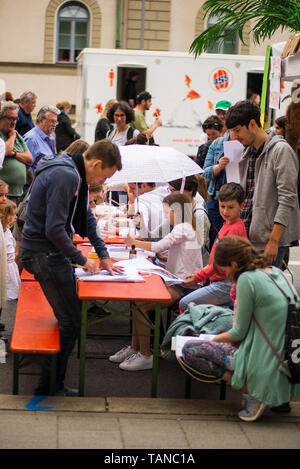 Munich,Allemagne- Mai 25,2019 : une femme est titulaire d'un parasol sur sa fille alors qu'elle peint au cours du Festival de Munich côté rue Banque D'Images