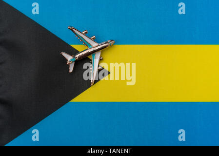 Avion sur la notion de drapeau Bahamas Voyages et tourisme. Avion jouet sur le drapeau à l'arrière-plan. Banque D'Images