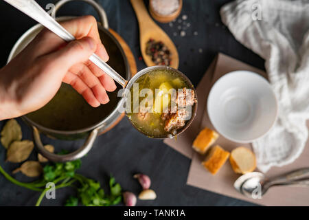 Par ailleurs chefs verser de la soupe dans un bol vide blanc, la préparation des aliments Banque D'Images