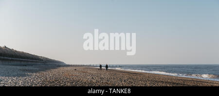 Horsey Gap, France - le 19 avril 2019:Vue panoramique de Horsey Gap beach au printemps, des silhouettes de personnes à pied par l'eau sur l'arrière-plan. Horsey bea Banque D'Images