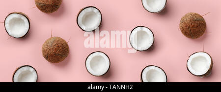 Avec motif sur coco mûre fond rose. Vue d'en haut. Copier l'espace. Pop art design, creative concept d'été. La moitié de la noix de coco dans un minimum de mise à plat Banque D'Images
