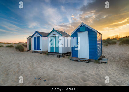Coucher de soleil sur une rangée de jolies cabanes de plage de Southwold sur la côte du Suffolk Banque D'Images