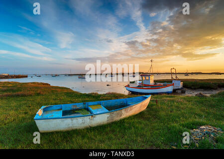 Magnifique coucher de soleil sur vieux bateaux de pêche amarrés sur l'embouchure de la rivière Alde à Aldeburgh sur la côte du Suffolk Banque D'Images