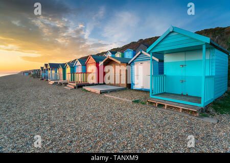 Magnifique coucher de soleil sur une rangée de cabines de plage aux couleurs vives à Milford on Sea sur la côte Hampshire Banque D'Images