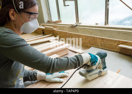 Jeune femme moud35 avec la machine de meulage angulaire en atelier Banque D'Images