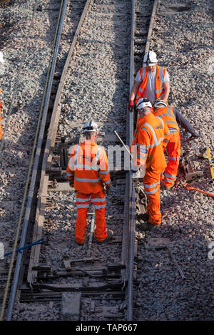 Network Rail Contractors et un superviseur en excès de compensation de ballast autour de points après le ballast a été remplacé. Banque D'Images