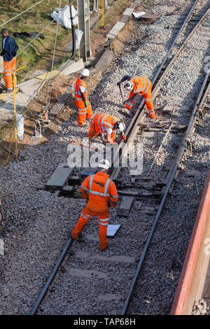 Network Rail Contractors et un superviseur en excès de compensation de ballast autour de points après le ballast a été remplacé. Banque D'Images