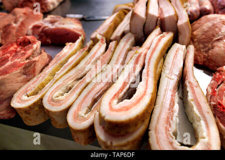 Et les tranches de lard salé frais morceaux de viande sont sur le comptoir de vente dans le marché. Banque D'Images