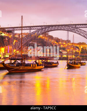 Superbe coucher de soleil sur la rivière Douro avec des bateaux illuminés, Vin Porto skyline et Le Pont Dom Luis I en arrière-plan, Portugal Banque D'Images