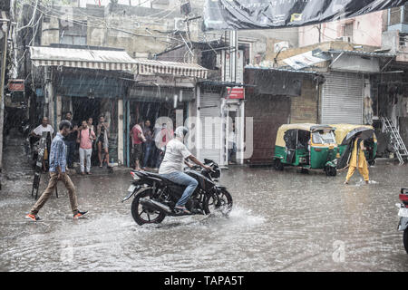 Une moto d'essayer de passer dans une rue inondée dans les pluies de mousson à New Delhi, Inde Banque D'Images