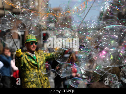 Les enfants essayent d'attraper les bulles d'un interprète sur la rue Bank Holiday lundi le long de la Royal Mile à Édimbourg. Banque D'Images