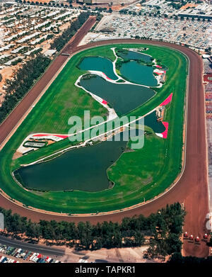 Cette photographie aérienne historique de 1974 montre le circuit de course Hollywood Park, aujourd'hui démoli, qui était célèbre depuis 75 ans comme lieu de course de chevaux pur-sang dans le comté de Los Angeles, en Californie, aux États-Unis. La piste a ouvert ses portes à Inglewood en 1938 et a fermé ses portes à la fin de la saison de course 2013. Le site de 298 hectares (121 hectares) est en cours de transformation en un centre résidentiel, de divertissement et de sports qui abrite le nouveau stade de Los Angeles de 70,000 places. Les matchs à domicile de deux équipes de la National football League (NFL), Los Angeles Chargers et Los Angeles Rams, y seront joués, tout comme le Super Bowl en 2022. Banque D'Images