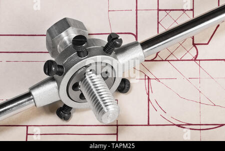 Mourir dans l'enfilage, clé sur le dessin technique détaillée. L'outil de coupe en acier lors du travail sur l'arbre de la vis à filetage métallique. La planification de projet. L'usinage de puce. Banque D'Images