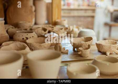 Collection de poterie. Bande de pots en argile non transformés frais placé sur une surface de travail en atelier équipé Banque D'Images