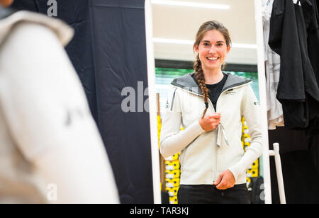 27 mai 2019, Hessen, Frankfurt/Main : Christa Riffel, le sport du vélo de course, ferme son manteau dans l'armoire. La Fédération allemande de sport olympique (DOSB) est l'envoi de 149 athlètes à Minsk/Bélarus pour la deuxième édition des Jeux (21 au 30 juin 2019). Les athlètes seront équipés de vêtements de l'équipe officielle. Photo : Andreas Arnold/dpa Banque D'Images