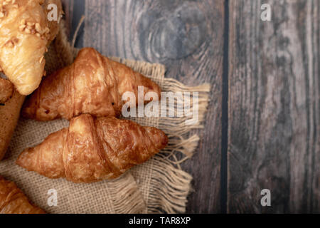 Les croissants sur le sac et table en bois Banque D'Images