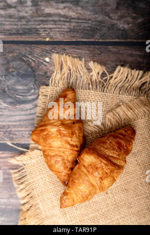 Les croissants sur le sac et table en bois Banque D'Images