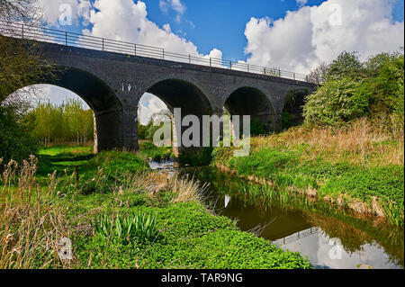 L'Itchen River dans le Warwickshire avec un viaduc voûté en brique de l'ancienne ligne de chemin de fer link Banque D'Images