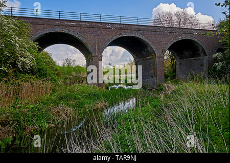 L'Itchen River dans le Warwickshire avec un viaduc voûté en brique de l'ancienne ligne de chemin de fer link Banque D'Images