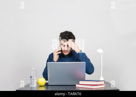 Frustré et a souligné l'audition des élèves de mauvaises nouvelles au sujet de l'université. Fatigué office worker sitting obtenir de mauvaises nouvelles inattendues par mobilephone. In situ de stress Banque D'Images