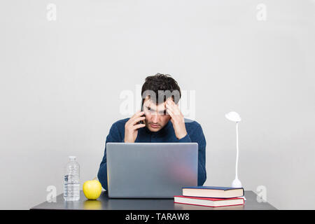 Frustré et a souligné l'audition des élèves de mauvaises nouvelles au sujet de l'université. Fatigué office worker sitting obtenir de mauvaises nouvelles inattendues par mobilephone. In situ de stress Banque D'Images