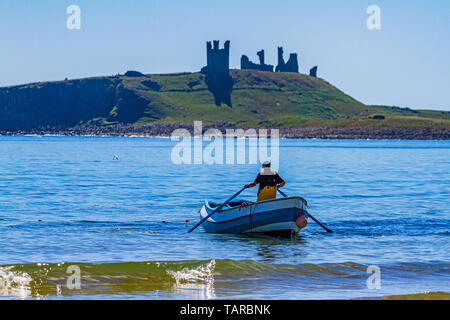Un aviron pêcheur coble, un bateau de pêche traditionnel, au large de la côte nord-est, de Northumberland, Dunstanburgh au Royaume-Uni. Banque D'Images