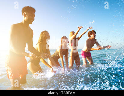 Groupe d'amis s'amuser à la plage avec la mer de l'eau Banque D'Images