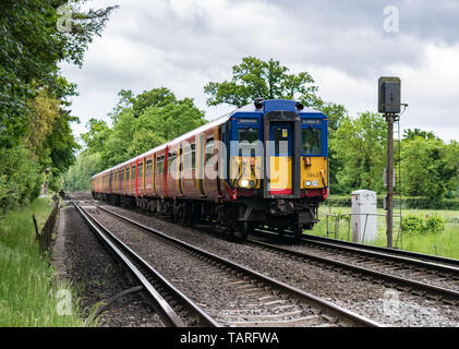 Un conducteur de train les ondes de sa classe 455 South Western Railway passenger service train passe un signal dans la campagne du Surrey, en direction de Waterloo. Banque D'Images