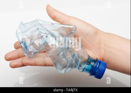 Recyclage du plastique thème. Bouteille en plastique bleu écrasé dans la main palm Banque D'Images