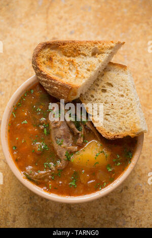 Un bol de soupe de gibier maison faite à partir de la viande du gibier mijoté d'os qui ont été mijotée dans une cocotte avec les légumes, les champignons et les herbes pour s Banque D'Images