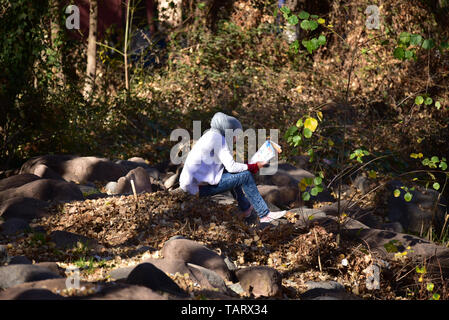 OURIKA/ MAROC- 5 janvier 2018. Jeune femme musulmane la lecture dans l'environnement naturel Banque D'Images