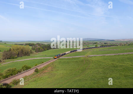 GB Railfreight class 66 66759 locomotive tirant un train sur la ligne de fret pittoresque à la carrière de Rylstone, au nord de Skipton, Yorkshire transportant la pierre. Banque D'Images