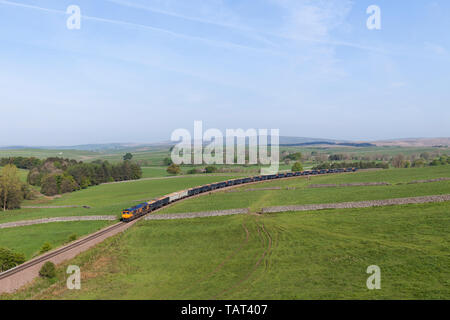 GB Railfreight class 66 66759 locomotive tirant un train sur la ligne de fret pittoresque à la carrière de Rylstone, au nord de Skipton, Yorkshire transportant la pierre. Banque D'Images