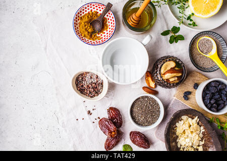 Flt laïcs de super-aliments - miel, dates, curcuma, citron, noix et chia sur fond blanc. Boisson saine cuisine concept. Banque D'Images