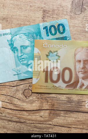 Billets de Devises : Dollar canadien et monnaie brésilienne : du vrai. Bils sur table rustique en bois. Banque D'Images