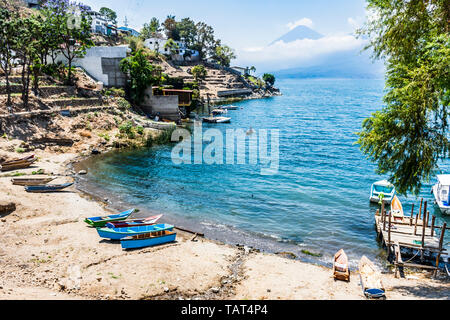 Bateaux tiré vers le haut sur la plage avec volcan Toliman sur horizon à lakeside village de San Antonio Palapo, Lac Atitlan, Guatemala. Banque D'Images