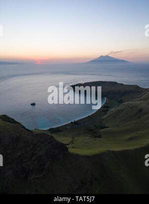 Vu d'une vue à vol d'oiseau, un cadre idyllique, île tropicale, Gili Banta, est éclairé par le soleil couchant juste à l'extérieur du Parc National de Komodo, en Indonésie. Banque D'Images