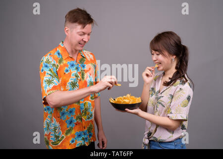 Couple de touristes ethniques multiples ayant des croustilles comme snack Banque D'Images