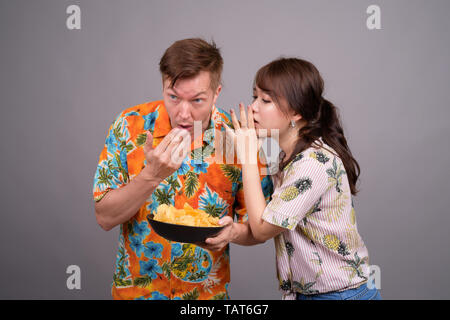 Couple de touristes ethniques multiples ayant des croustilles comme snack Banque D'Images