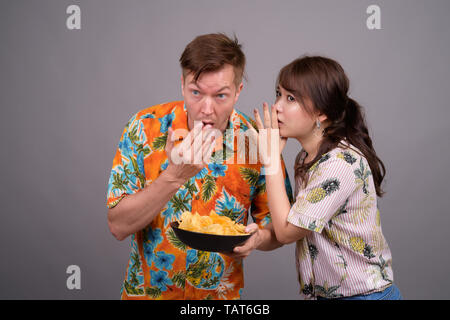 Couple de touristes ethniques multiples ayant des croustilles comme snack Banque D'Images