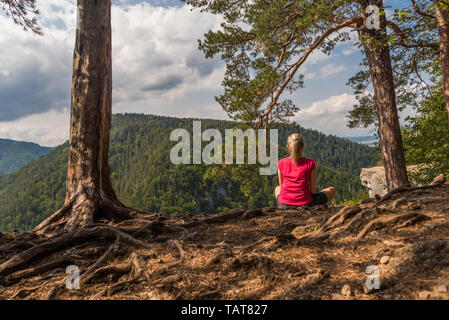 Femme assise en posture joga à sur les montagnes Banque D'Images