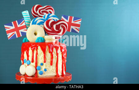 Royaume-uni le goutte-à-tendance candyland fantasy gâteau avec rouge, blanc et bleu décorations, sucettes et drapeaux avec copie espace. Banque D'Images