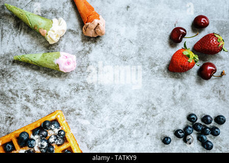 Fond d'aliments sucrés et savoureux avec des fruits rouges et des gaufres, avec l'espace négatif pour la conception d'été. Banque D'Images