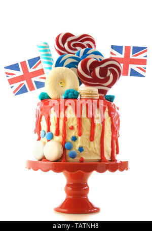 Royaume-uni le goutte-à-tendance candyland fantasy gâteau avec rouge, blanc et bleu décorations, sucettes et les drapeaux sur fond blanc. Banque D'Images