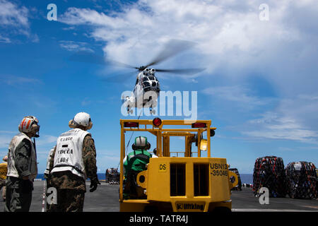 190527-N-IQ884-1478 de l'OCÉAN PACIFIQUE (le 27 mai 2019) marines affectés à la lutte contre quart cargaison comme un commandement militaire Maritime SA-330J des livraisons d'hélicoptères Puma à partir de fournitures de marchandises et de munitions ship USNS Richard E. Byrd (T-AKE 4) de navire d'assaut amphibie USS Boxer (DG 4) lors d'un ravitaillement vertical en mer. Le groupe amphibie Boxer (ARG) et 11e Marine Expeditionary Unit (MEU) sont déployés dans le domaine de la 7ème flotte américaine à l'appui des opérations de la stabilité régionale, de rassurer les partenaires et alliés, et maintenir une présence à répondre à n'importe quelle crise allant de l'assistance humanitaire à co Banque D'Images