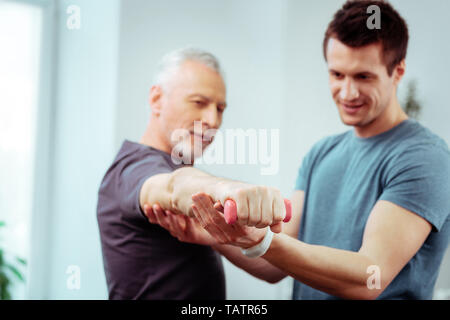 Développement des muscles. Focus sélectif d'un homme part avec un petit haltère dans c Banque D'Images