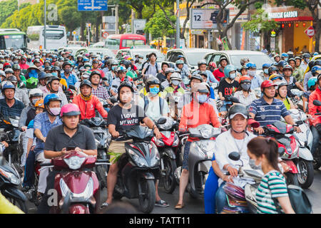 Ho Chi Minh Ville, Vietnam - 09 avril, 2019 : une foule sur les motos attendre le feu de circulation à l'intersection achalandée durant l'heure de pointe. Banque D'Images