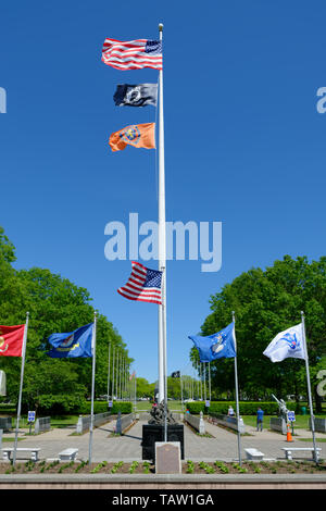 East Meadow, New York, USA. 25 mai, 2019. L'écorchage à partir d'un grand mât sont, de haut en bas, le drapeau américain, le pow-MIA drapeau, et le Nassau County State of New York drapeau. Il est entouré par des mâts, chaque battant un pavillon militaire des Forces armées des Etats-Unis - armée, marine, Marine Corps, Armée de l'air, Garde côtière canadienne, au Veterans Memorial Plaza à Eisenhower Park sur Long Island. Credit : Ann Parry/ZUMA/Alamy Fil Live News Banque D'Images