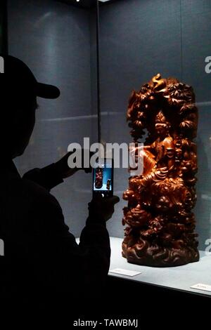 Beijing, Chine. 28 mai, 2019. Un visiteur prend des photos d'une sculpture d'art affichées à l'exposition d'Art Sculpture Zheng Guoming à Beijing, capitale de Chine, le 28 mai 2019. Environ 70 morceaux de bois, de pierre, de jade et d'œuvres d'art sculpture sur bambou faites par Zheng Guoming, un maître des arts chinois et de l'artisanat, sont affichés ici. L'exposition durera jusqu'au 12 juin. Credit : Cui Bowen/Xinhua/Alamy Live News Banque D'Images