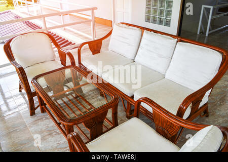 Ensemble de canapé en bois avec table en verre et chaises sur le balcon d'intérieur de maison - Canapé rotin Banque D'Images